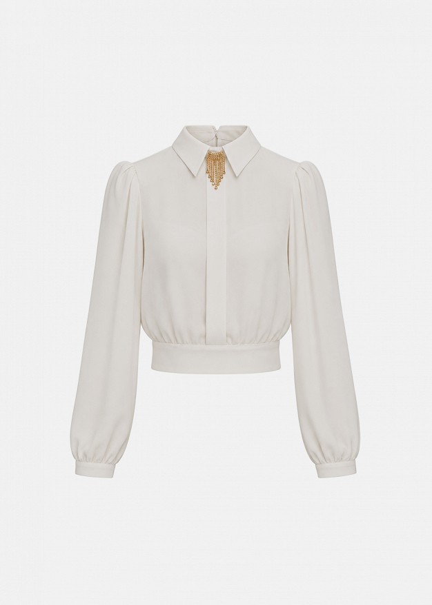 Blouse in statement shoulders and brooch