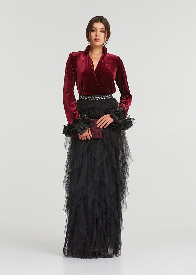 A blouse with a velvet look and feathered cuffs