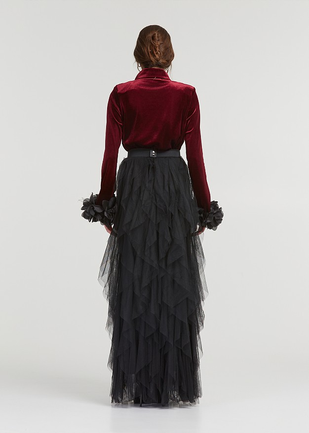 A blouse with a velvet look and feathered cuffs