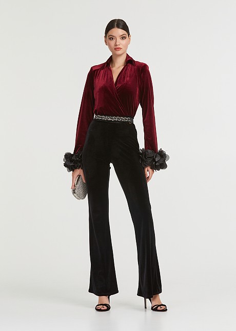 A blouse with a velvet look and feathered cuffs