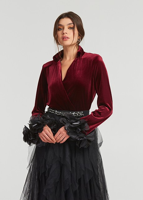 A blouse with a velvet look and feathered cuffs