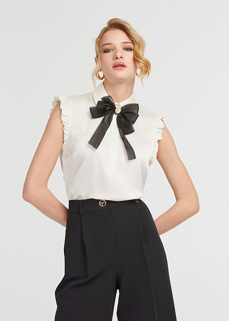 Sleeveless top with ruffles and bow